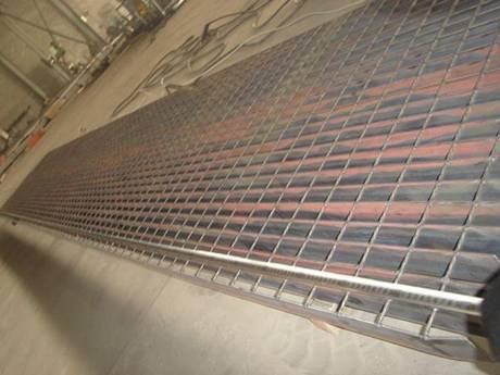 A welded low carbon steel grating on the ground.