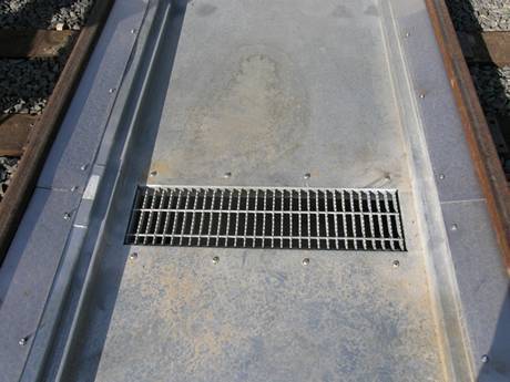 Recessed steel grating over cross drain.