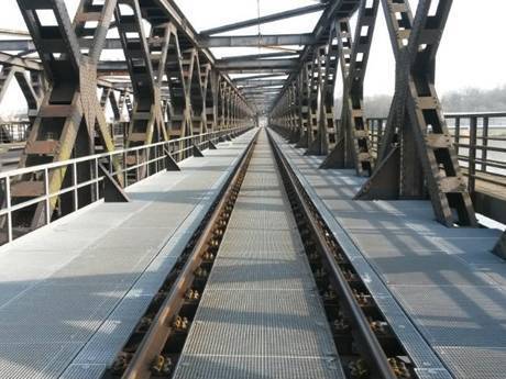 Steel grating walkway along the train rails.
